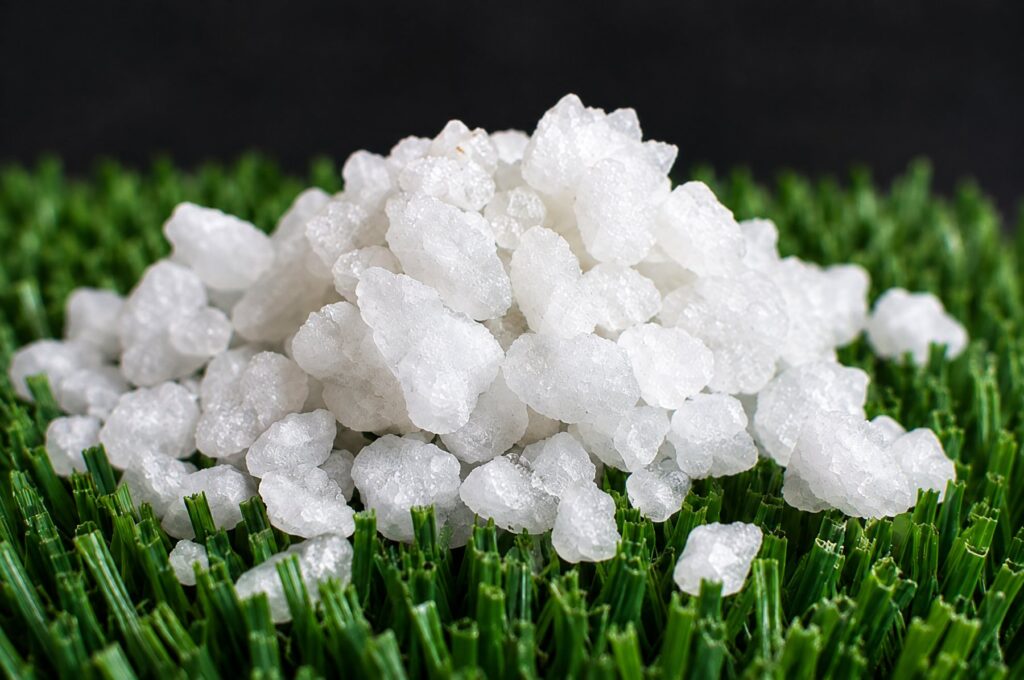 White aragonite infill granules on synthetic turf
